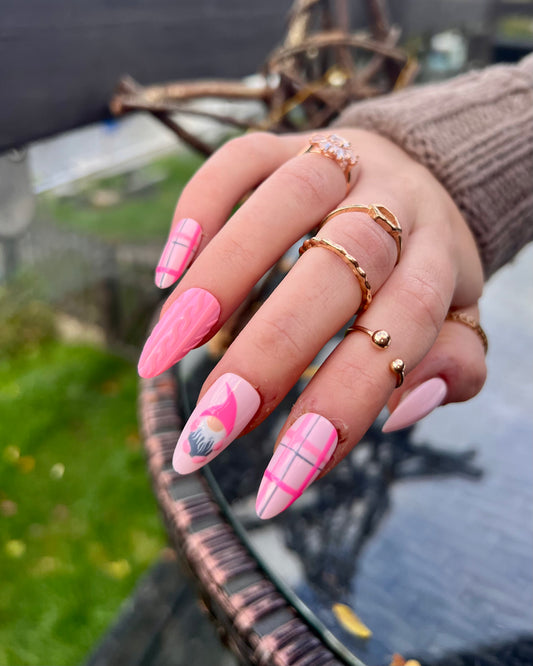 Bright and baby pink christmas gonk nails with tartan and sweater details in mid almond.