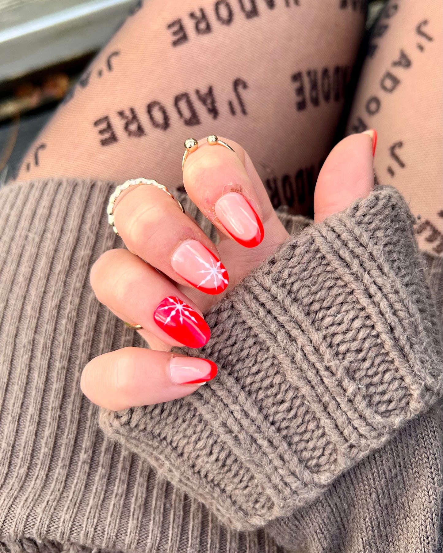 Cute red and nude christmas winter fake nails with little winter snowflakes pattern on.